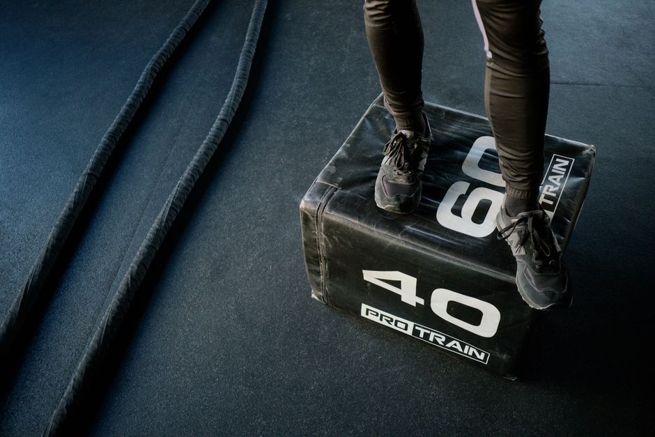 Engage in high-intensity gym workout using battle ropes and a sturdy plyo box for cardio and strength.